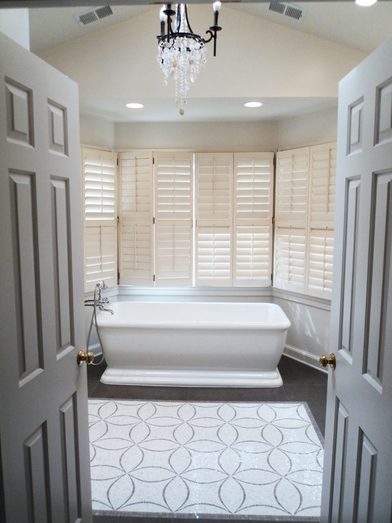 bathroom renovation free standing tub tile rug feature chandelier and large bay windows