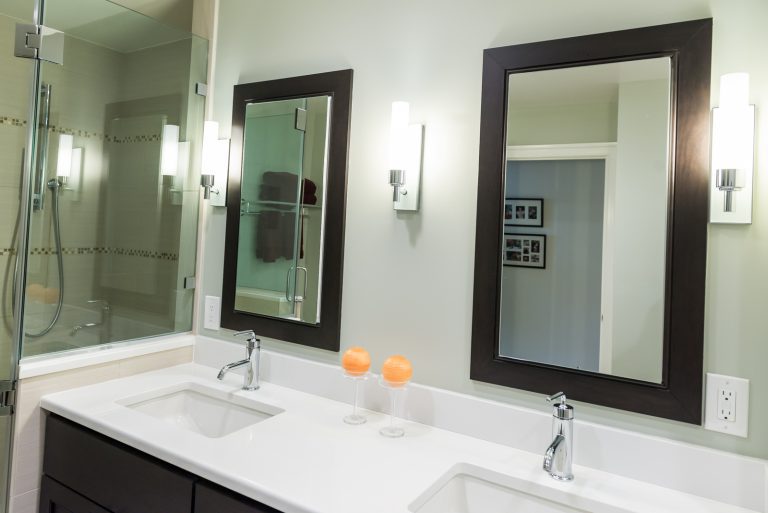 sleek modern bathroom neutral colors sage green double sink vanity sconce lighting