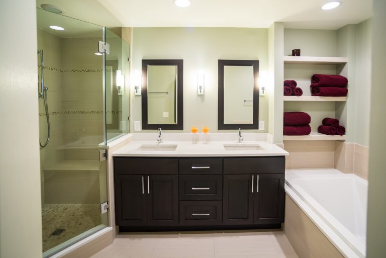 sleek modern bathroom neutral colors sage green dark wood double sink vanity separate tub and shower