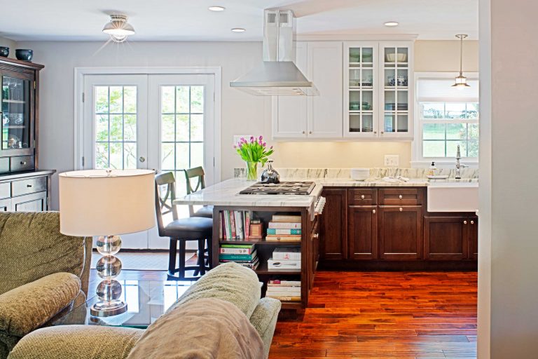 french doors and open shelving on end of peninsula kitchen flows into living area