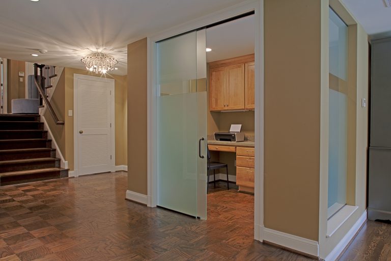 open and sleek design frosted glass sliding door leads to office space warm color tones