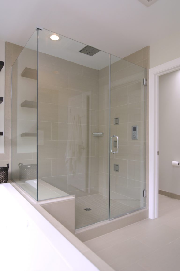 large separate shower stall with glass doors and built in bench and waterfall shower head