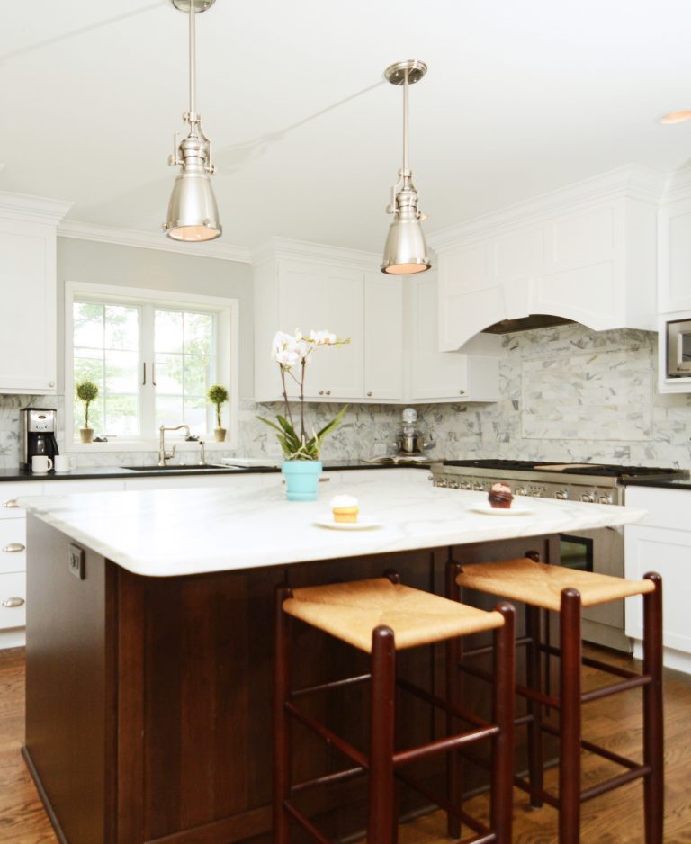 bright renovated kitchen white outer cabinets pendant lighting hanging over dark wood island
