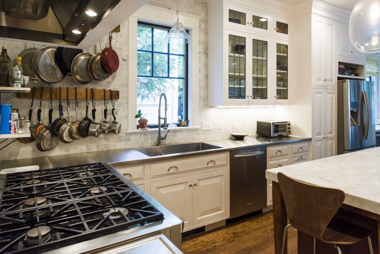 bright kitchen wood floors island stainless steel appliances glass door upper cabinets