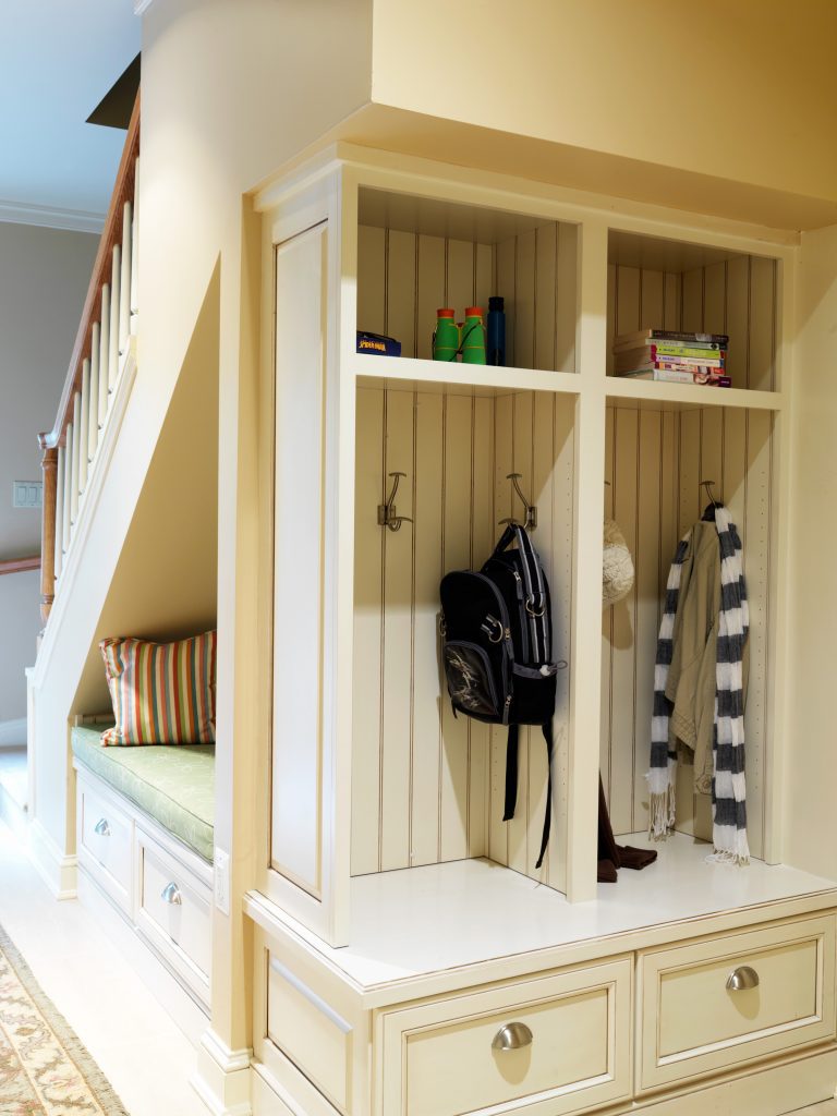 bright renovated mudroom built in cubby area and seating under stairs