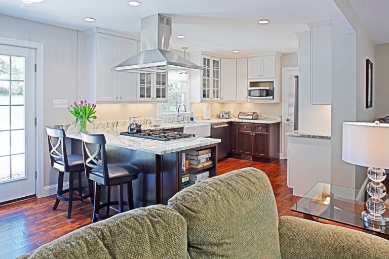 bright kitchen white and dark contrast flows into living area