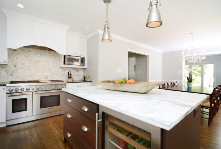 bright and open kitchen large range with hood pendant lighting hanging over dark wood island with beverage fridge