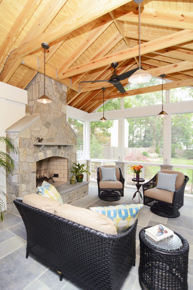 screened-in porch addition natural wood ceiling flagstone floor fireplace with ceiling fan pendant lights