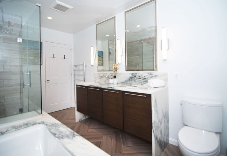 double sink dark wood vanity with waterfall edge marble countertops