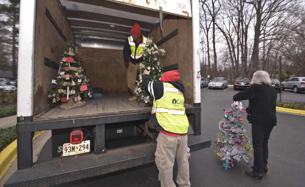 The team carefully unloads the decorated holiday trees