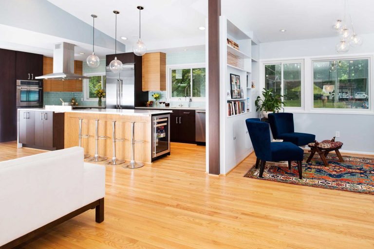 modern kitchen flows into living area pendant lighting over island vaulted ceiling
