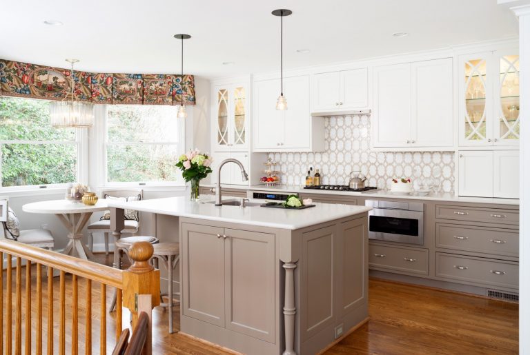 bright kitchen neutral color palette gray toned lower cabinetry white uppers wood floors island with pendant lighting