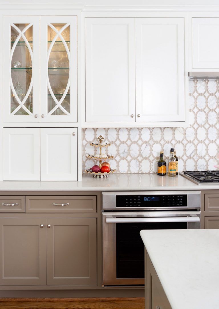 neutral color palette kitchen upper cabinets with glass door design stainless steel appliances geometric backsplash tile