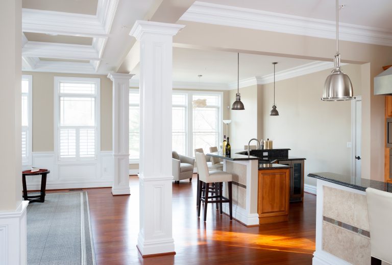 open concept craftsman style kitchen bright white coffered ceiling natural wood tones large windows and pendant lighting