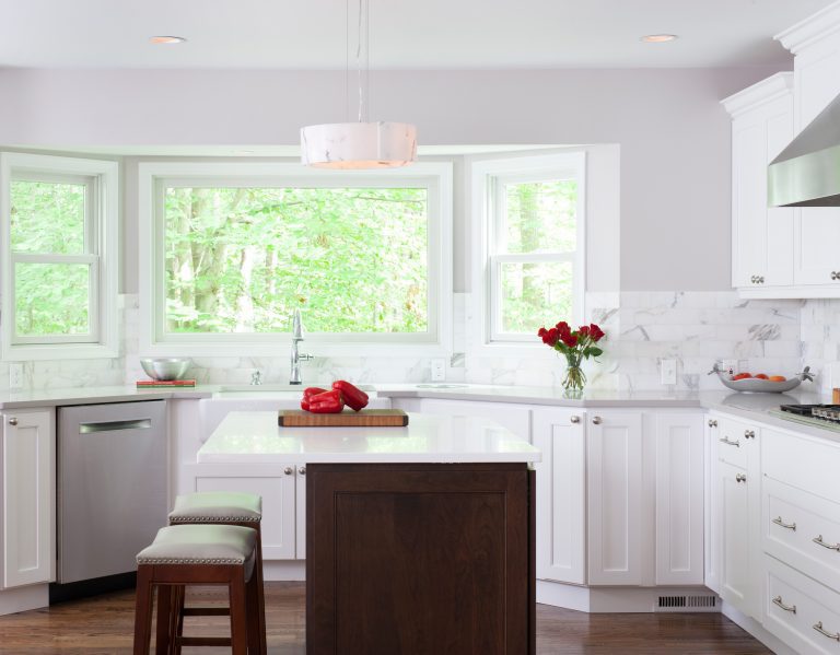 island seating in bright white kitchen with large bay window