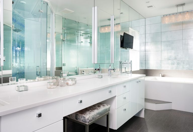 modern bathroom mirror wall vanity with white cabinets reflective tiles over bathtub