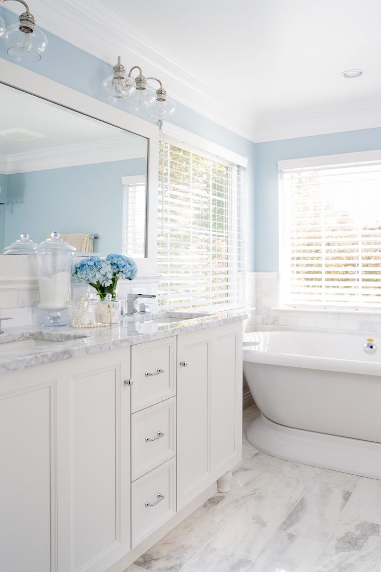 white and blue farmhouse style bathroom white cabinetry double sink vanity freestanding tub marble floors