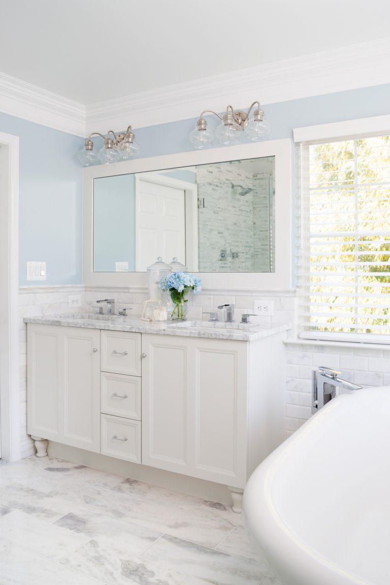 traditional farmhouse style bathroom white and blue color palette double sink vanity crown molding and freestanding tub