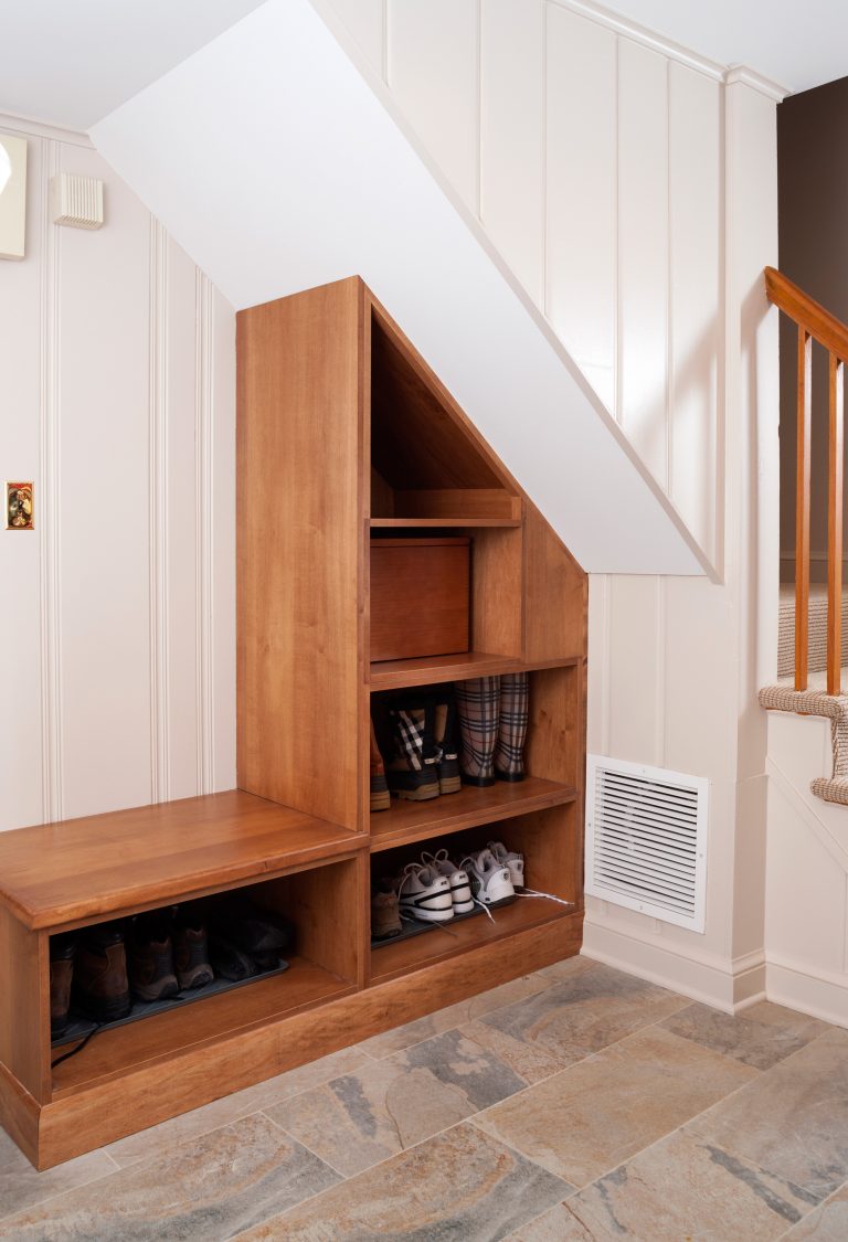 built in storage shelves and bench under stairs