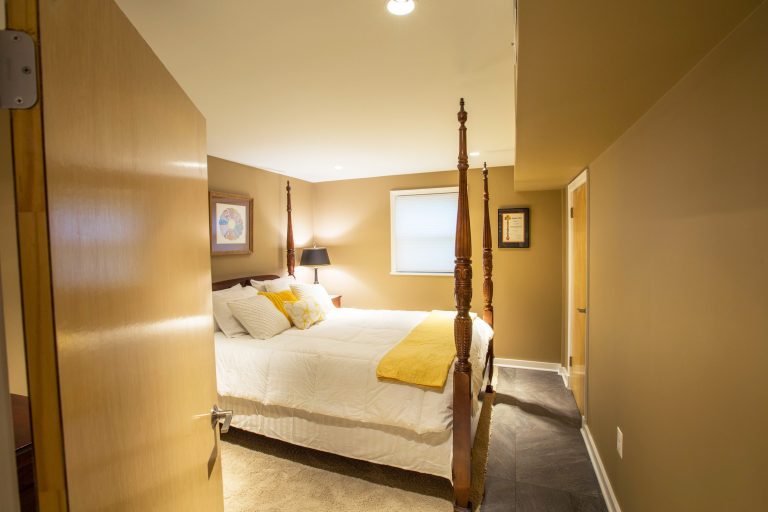 renovated basement bedroom yellow color tones cement floor
