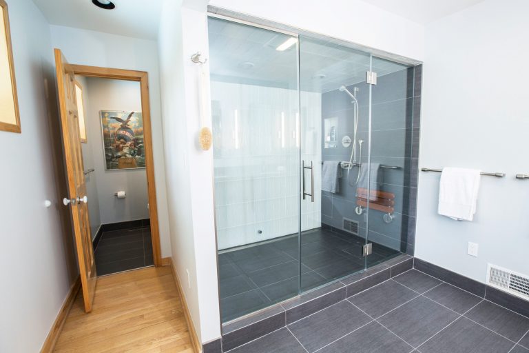 large modern shower with glass door white and dark gray tiles