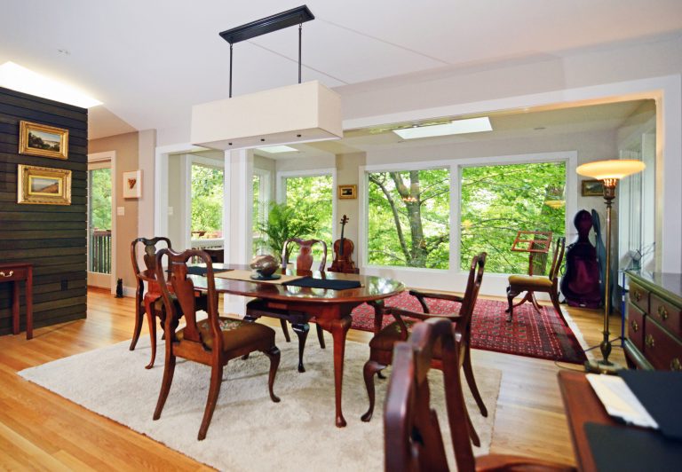 dining room open to living area eclectic style large windows wood floors and feature wall