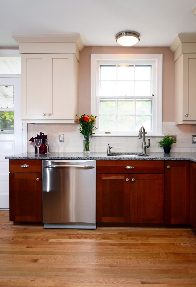 traditional style kitchen wood floors stainless steel appliances dark lower cabinets white upper cabinets window over sink