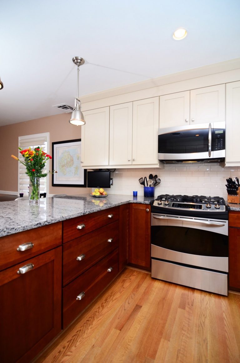 traditional style kitchen wood floors dark lower cabinets white upper cabinets stainless steel appliances
