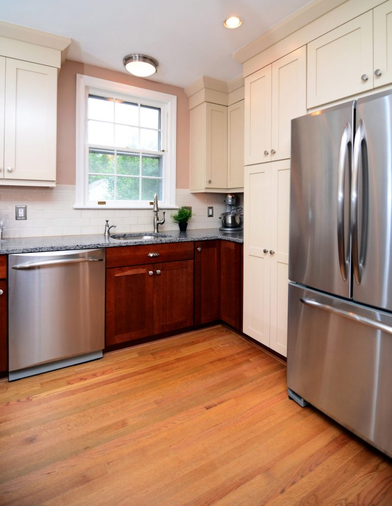 traditional style kitchen wood floors dark lower cabinets white upper cabinets stainless steel appliances