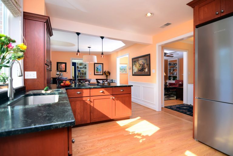 warm and inviting traditional kitchen medium wood cabinetry flows into living area pendant lighting over peninsula