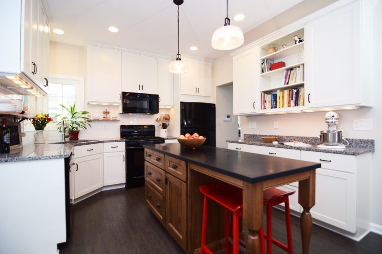 renovated kitchen white outer cabinetry with open shelving dark wood floors and dark wood island with seating and pendant lighting