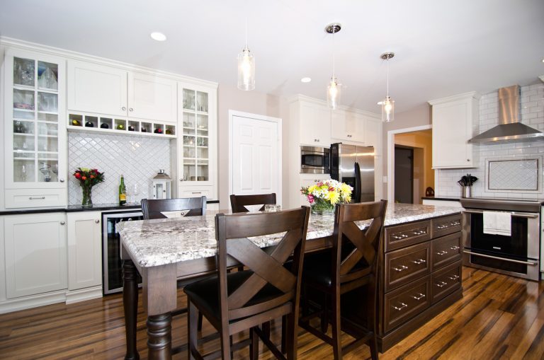 farmhouse kitchen with white cabinetry and dark wood island with seating bar area pendant lighting and recessed lighting wood floors