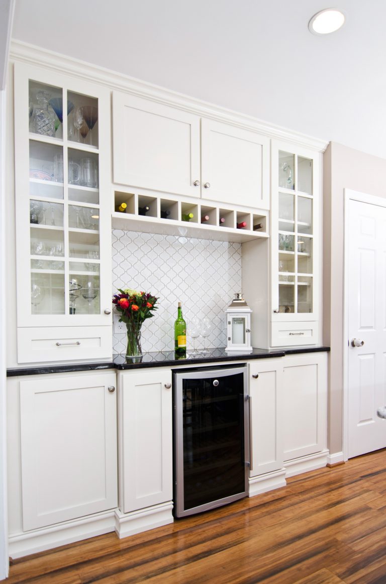 bar area in farmhouse style kitchen white cabinetry with glass door uppers wine storage and beverage refrigerator