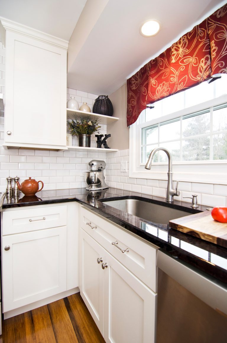 white cabinetry stainless steel sink and appliances open shelving storage recessed lighting black countertops white subway tile backsplash