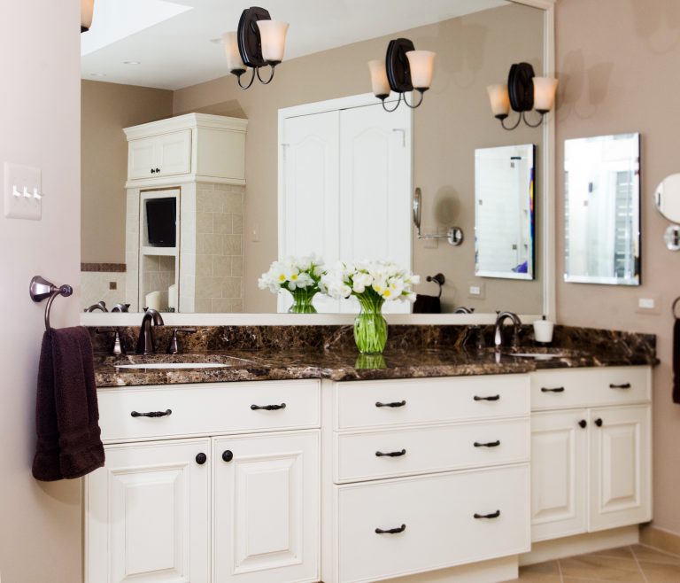 traditional style bathroom neutral color palette double sink vanity white cabinetry mirror wall with sconce lighting