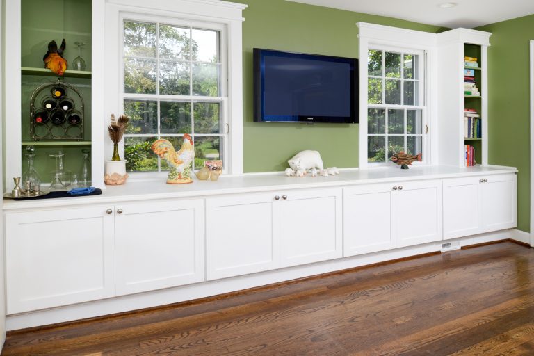 built-in white cabinetry entertainment storage wall mount flat screen tv light green walls