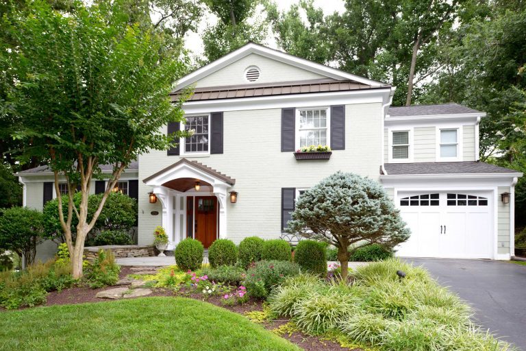 front of maryland home curb appeal white brick with wood door garage and black shutters