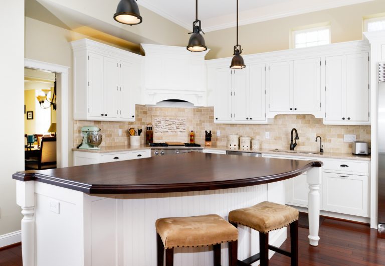 white cabinet kitchen pendant lighting over large center island with curved edge