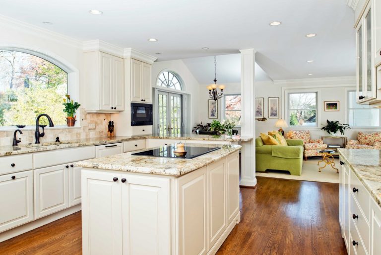 bright kitchen with island and peninsula flows into living area french doors