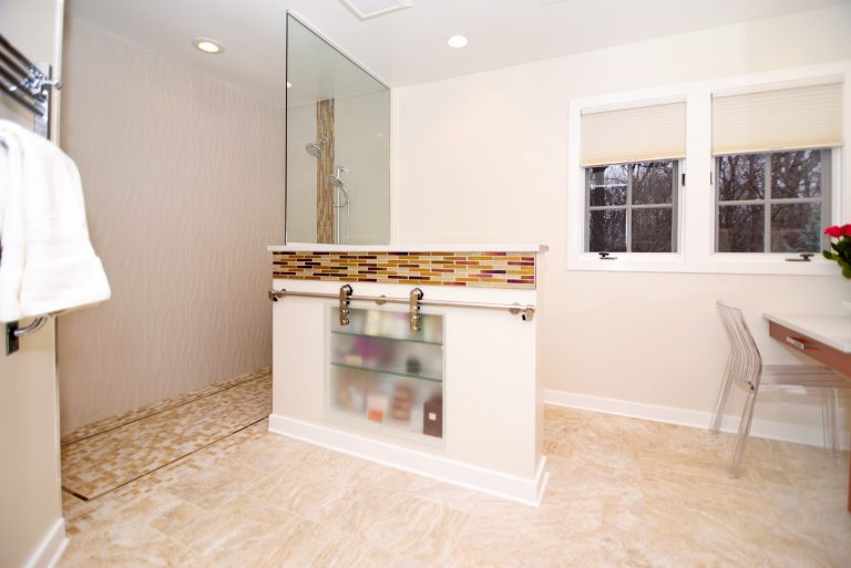 large glass shower stall half wall with mosaic tile detail and built in storage