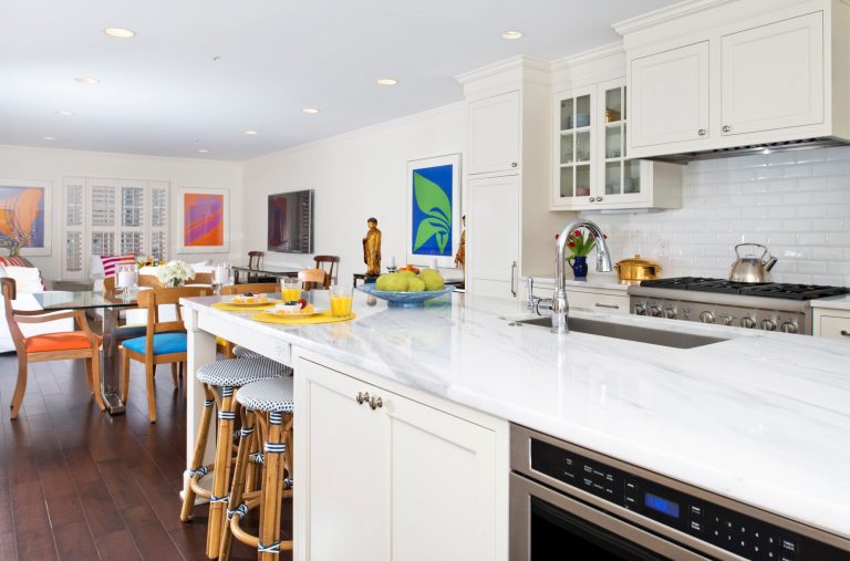 bright white eat in kitchen with dark wood floors island with seating stainless steel appliances