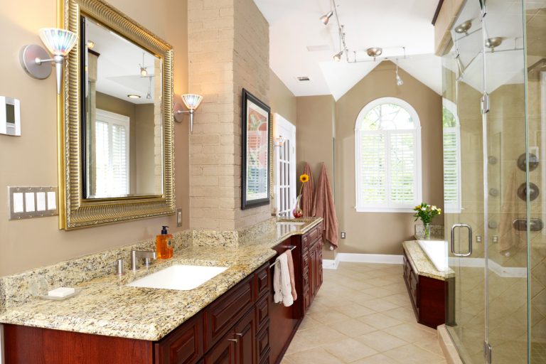 double sink dark wood vanity lots of counterspace separate bathtub and shower high ceilings large window traditional style tan neutral color palette