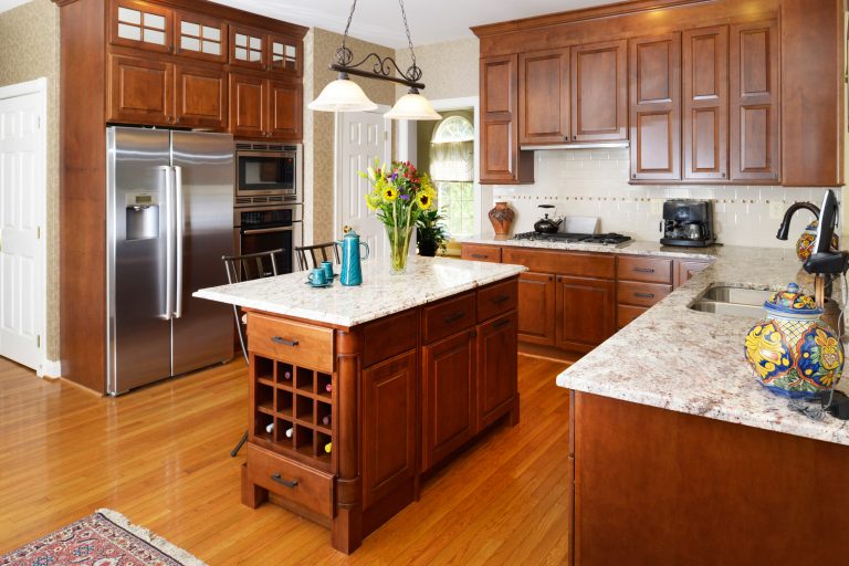 traditional country style kitchen medium wood cabinetry uppers with glass doors island with seating and wine storage wood floors stainless steel appliances