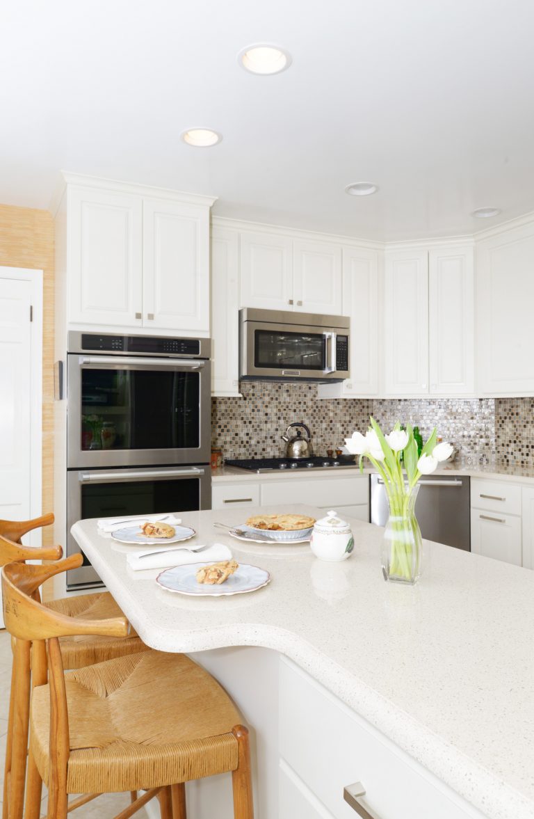 bright white kitchen with peninsula seating mosaic tile backsplash stainless steel appliances