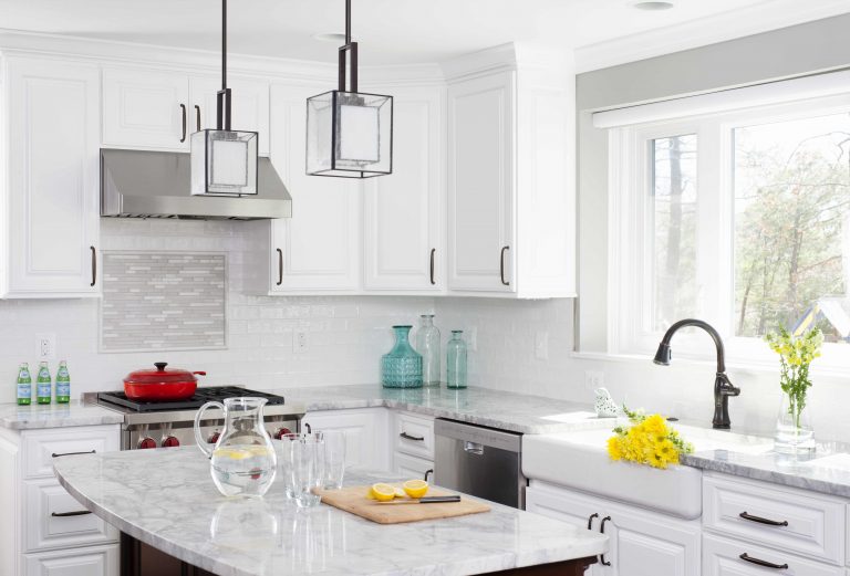 bright kitchen with window over farmhouse sink and pendant lighting over island