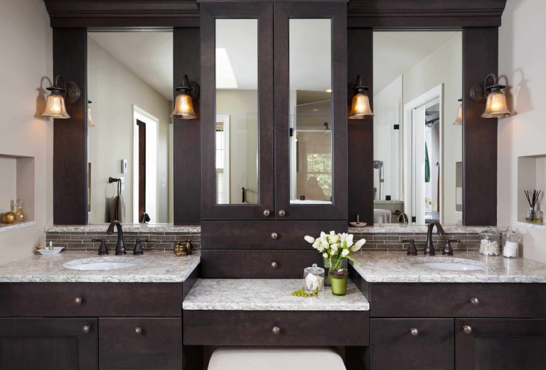 dark wood vanity with double sinks and built in makeup area plenty of storage sconce light