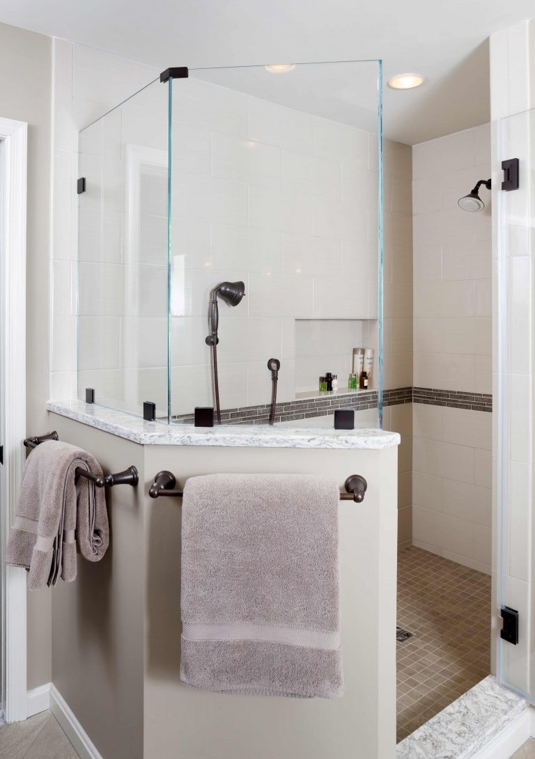 separate shower stall half wall with glass built in storage nook and tile stripe detail neutral color palette