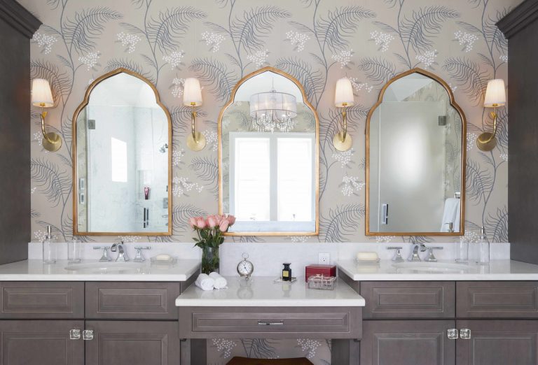 elegant traditional bathroom neutral color palette gray stained cabinetry double sinks and built in makeup vanity floral wallpaper sconce lighting
