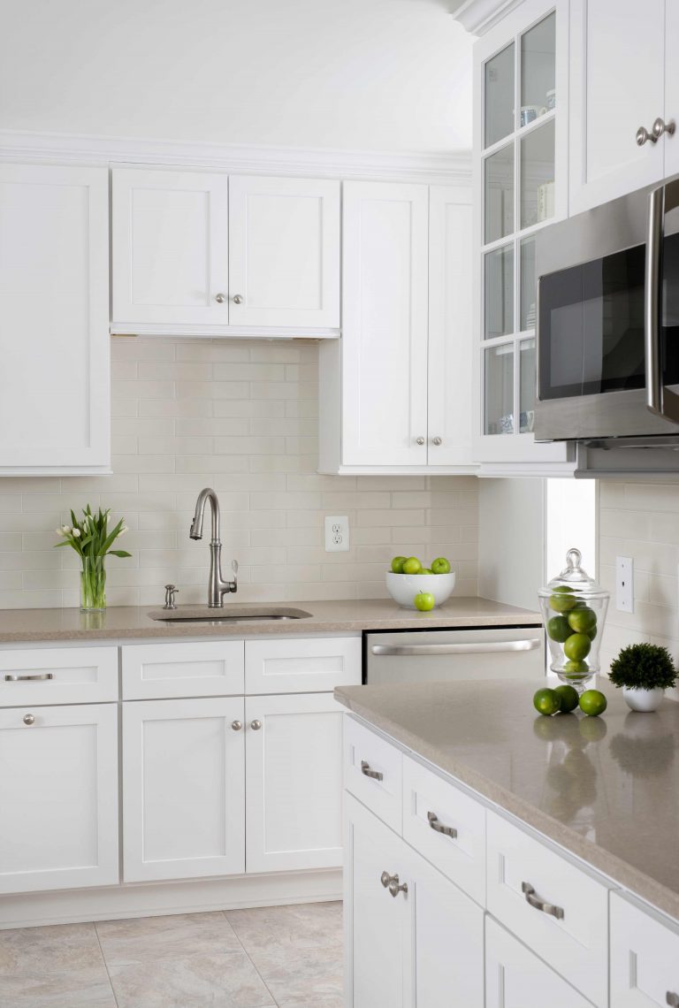 white and bright kitchen neutral color palette glass front cabinets built in microwave