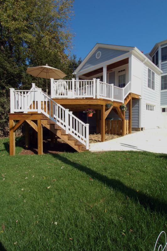 second story back deck addition on blue dc home with stairs to yard